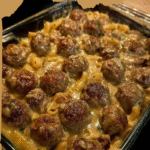 Swedish Meatballs Recipe served with creamy gravy and buttered noodles, garnished with fresh parsley and lingonberry jam.